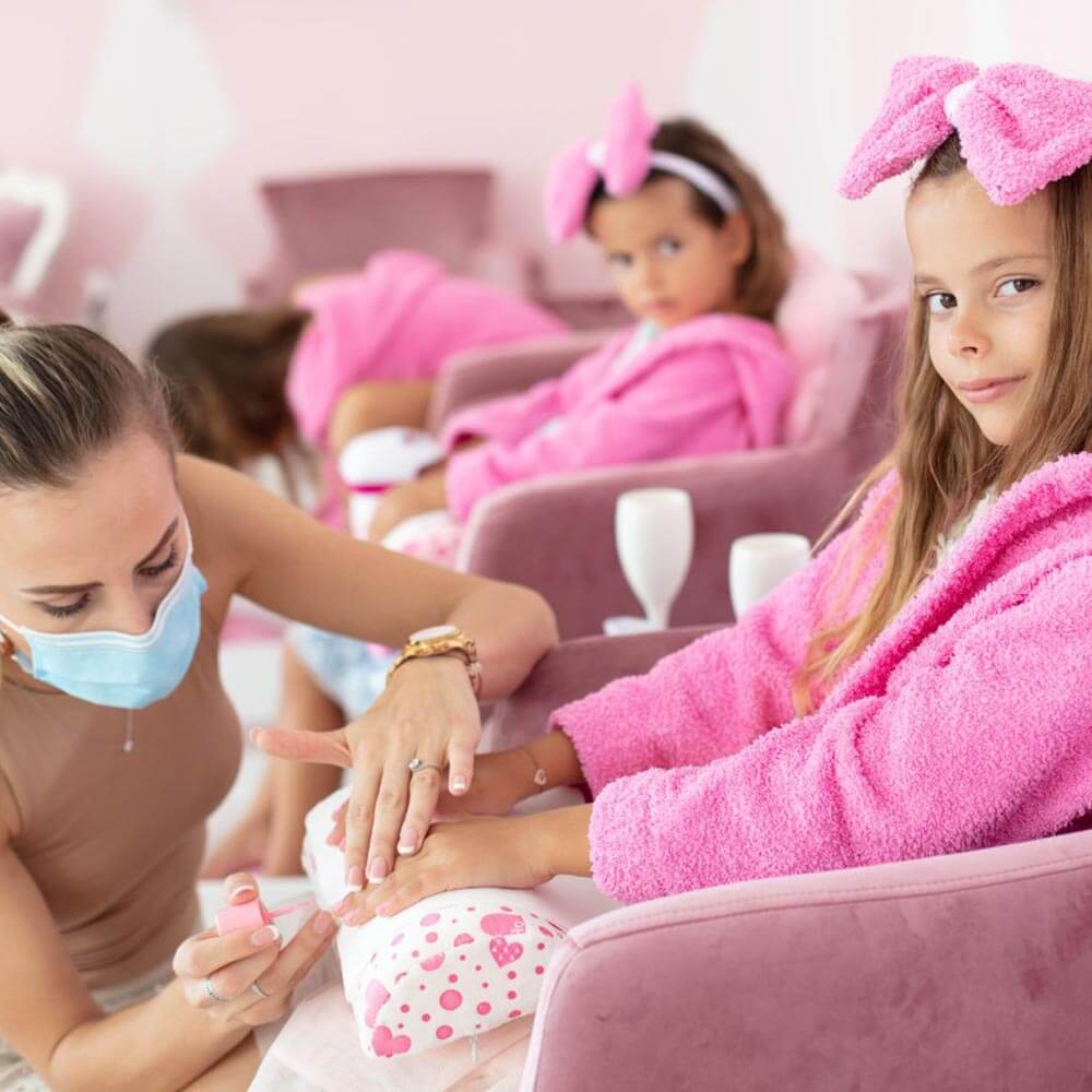 Women Applying Nail Paint On Little Girls Nails
