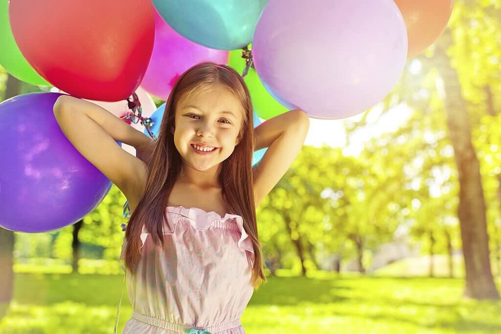 Girl holding the colored air balloons in party games